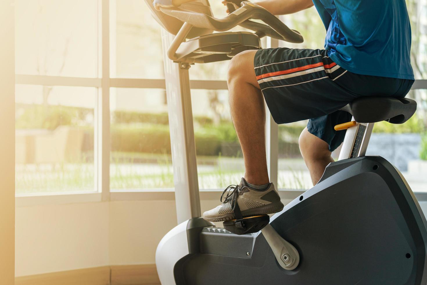 Cerca de un hombre ejercicio en el gimnasio en bicicleta en bicicleta en el gimnasio foto