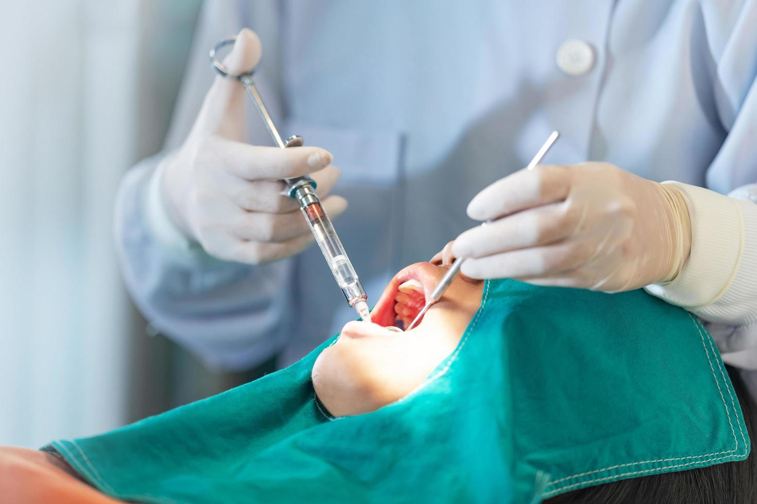 Female dentist standing in dentist office work with light curing seal photo