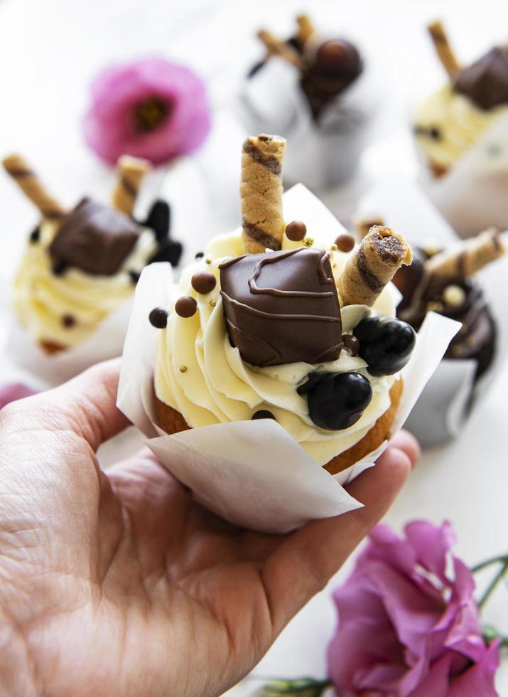 cupcake de chocolate en la mano de una mujer foto