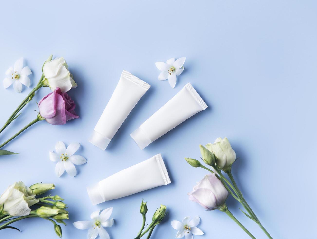 White tubes of cream on a blue background photo