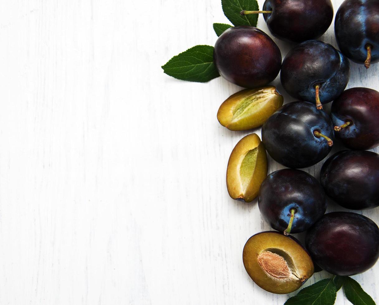 Sweet plums on a wooden background photo