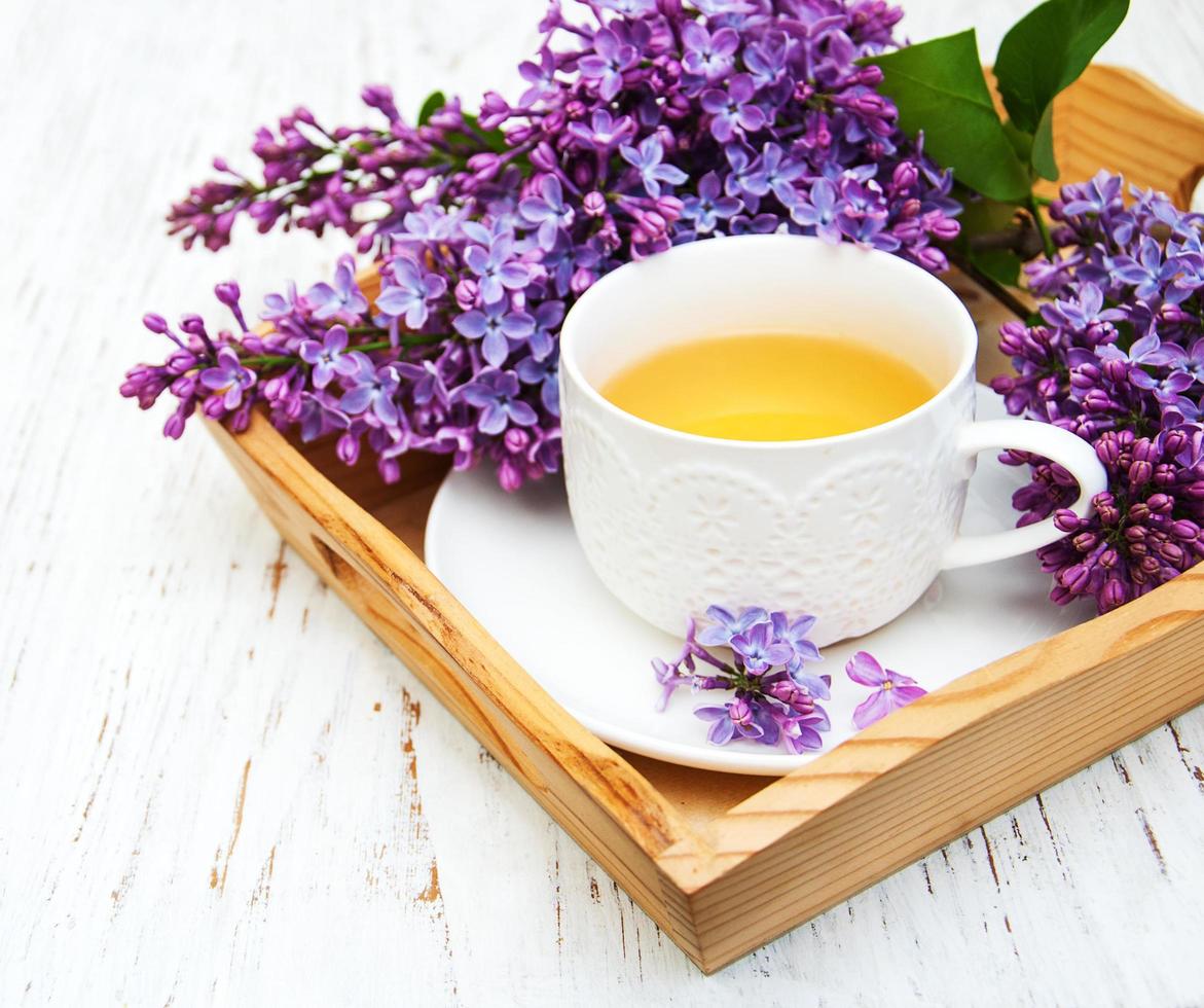 Cup of tea and lilac flowers photo