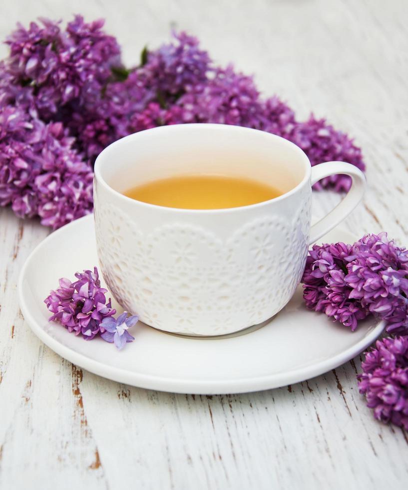 Cup of tea and lilac flowers photo