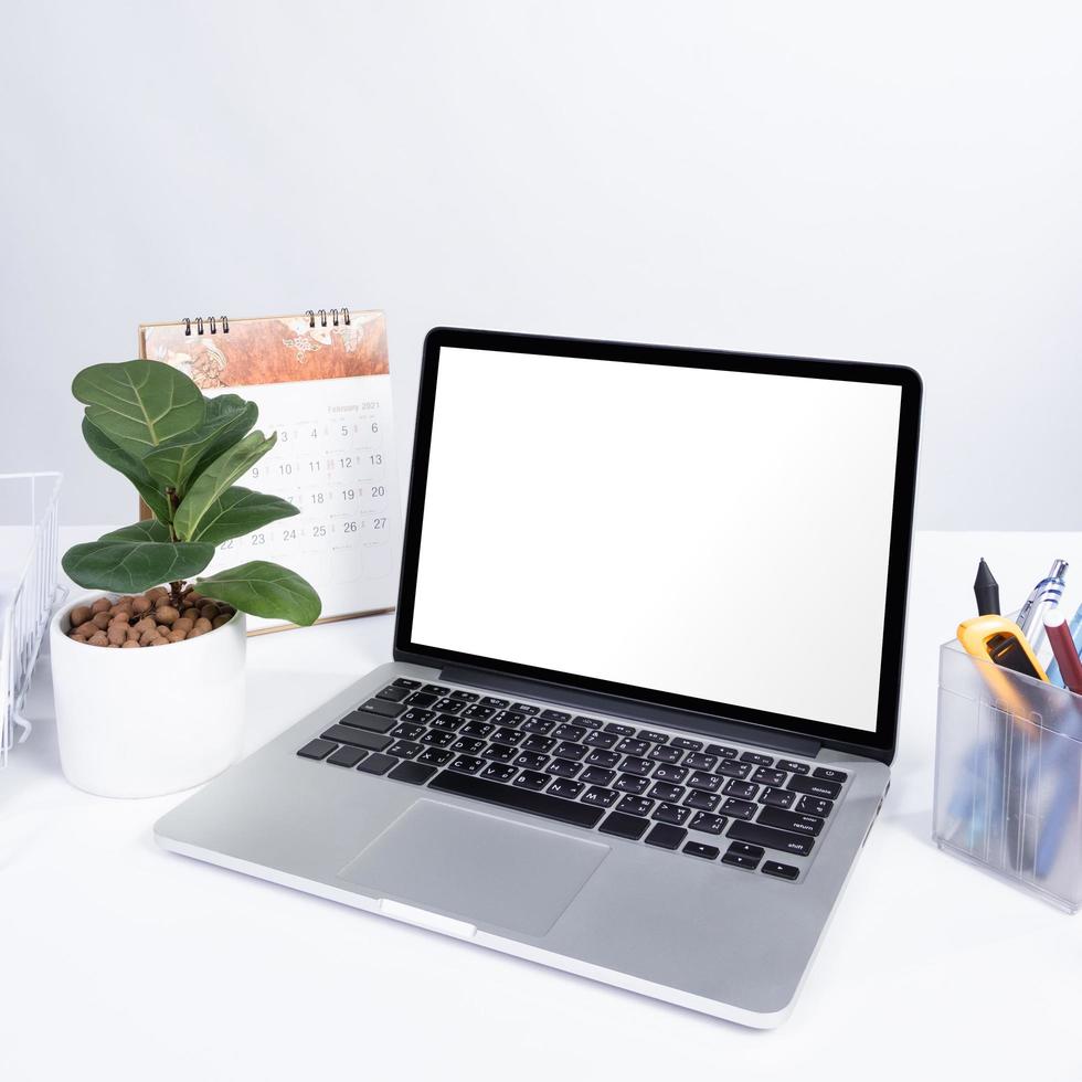 laptop blank screen mock up at the white office desk photo