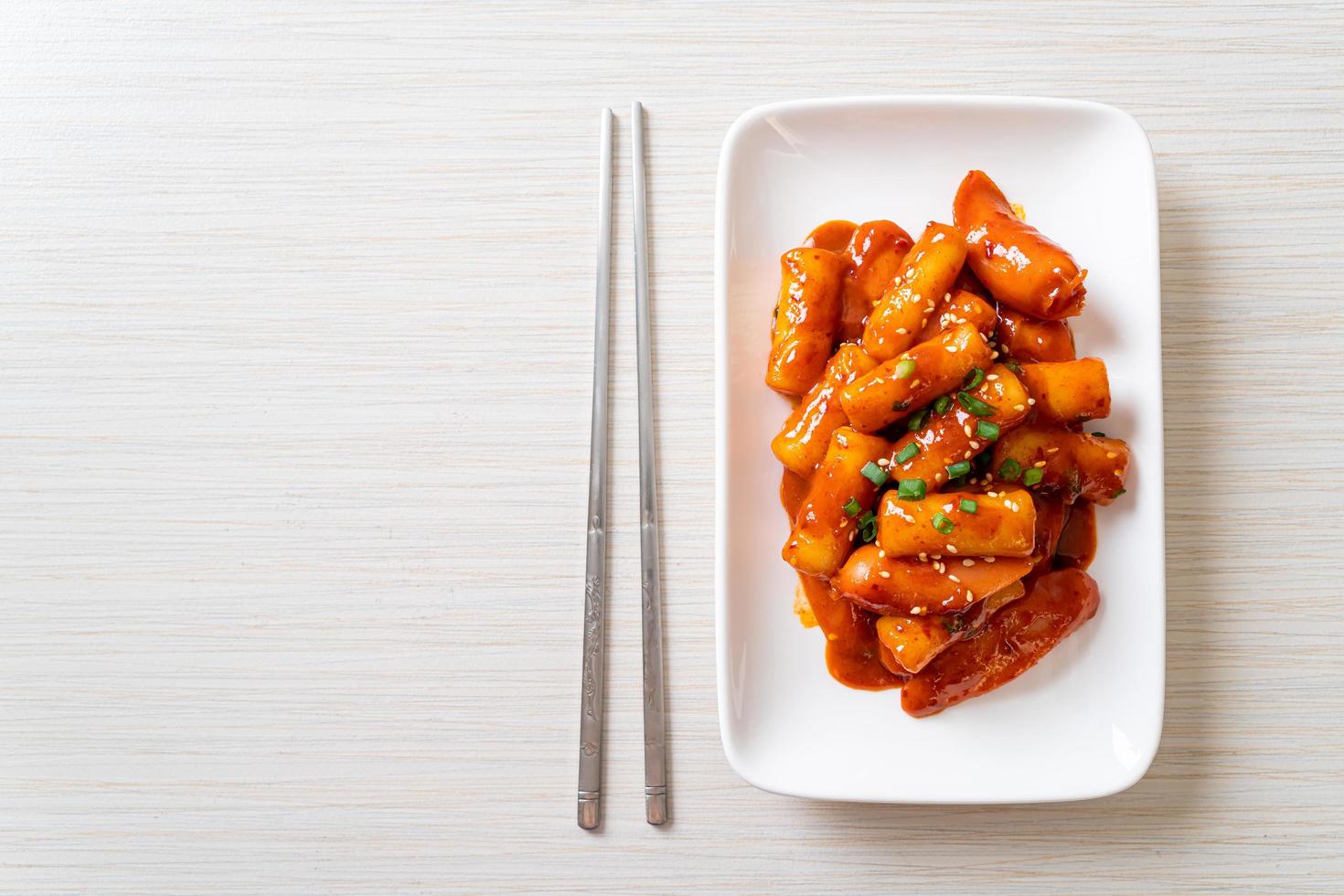 Korean rice cake stick with sausage in spicy sauce photo