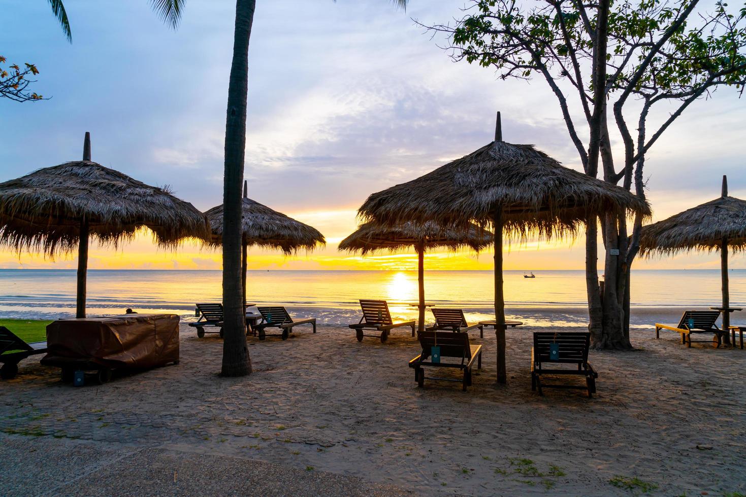 Umbrella and chair on tropical beach with sunrise photo