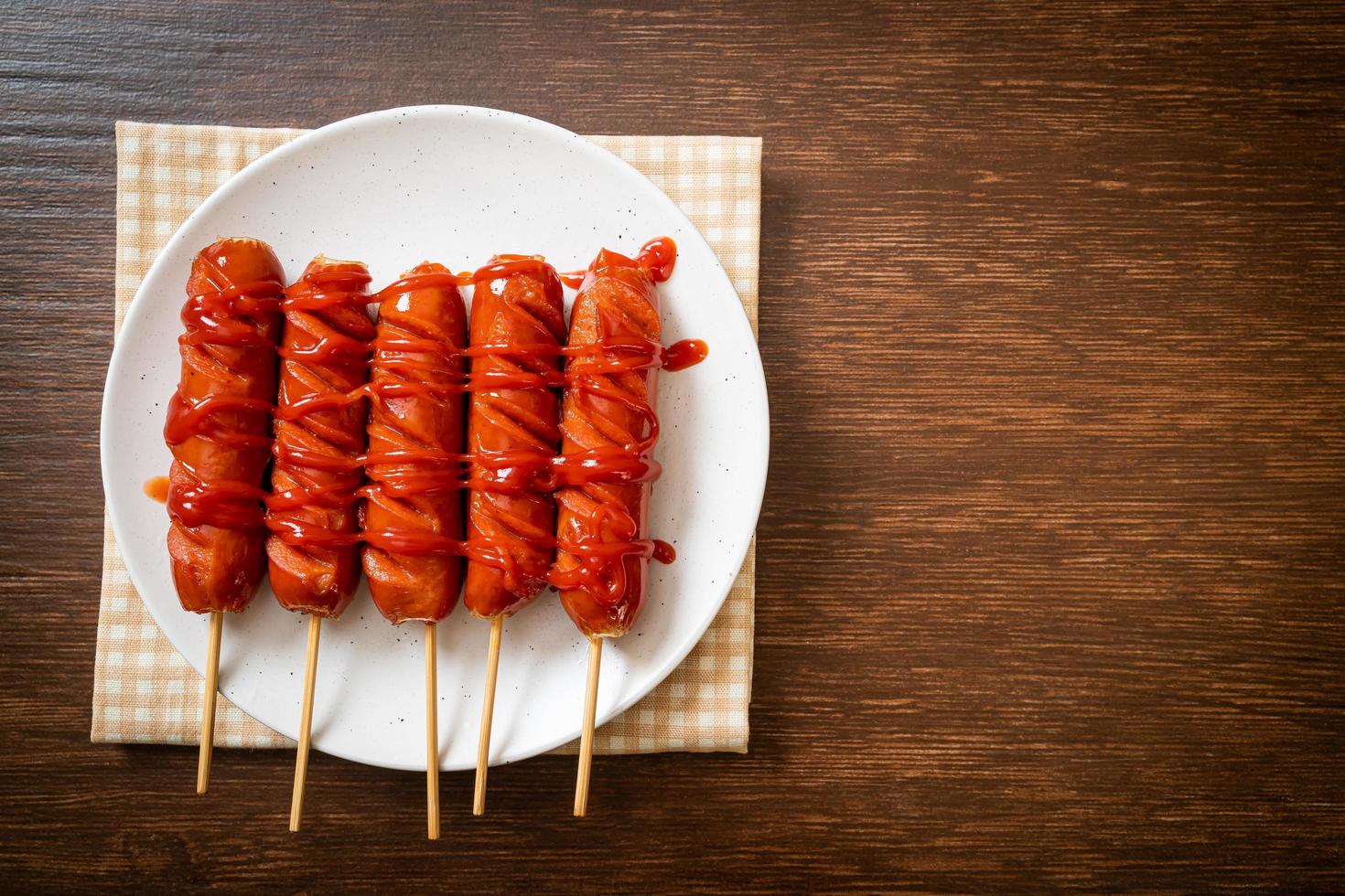 Brocheta de salchicha frita con salsa de tomate en una placa blanca. foto