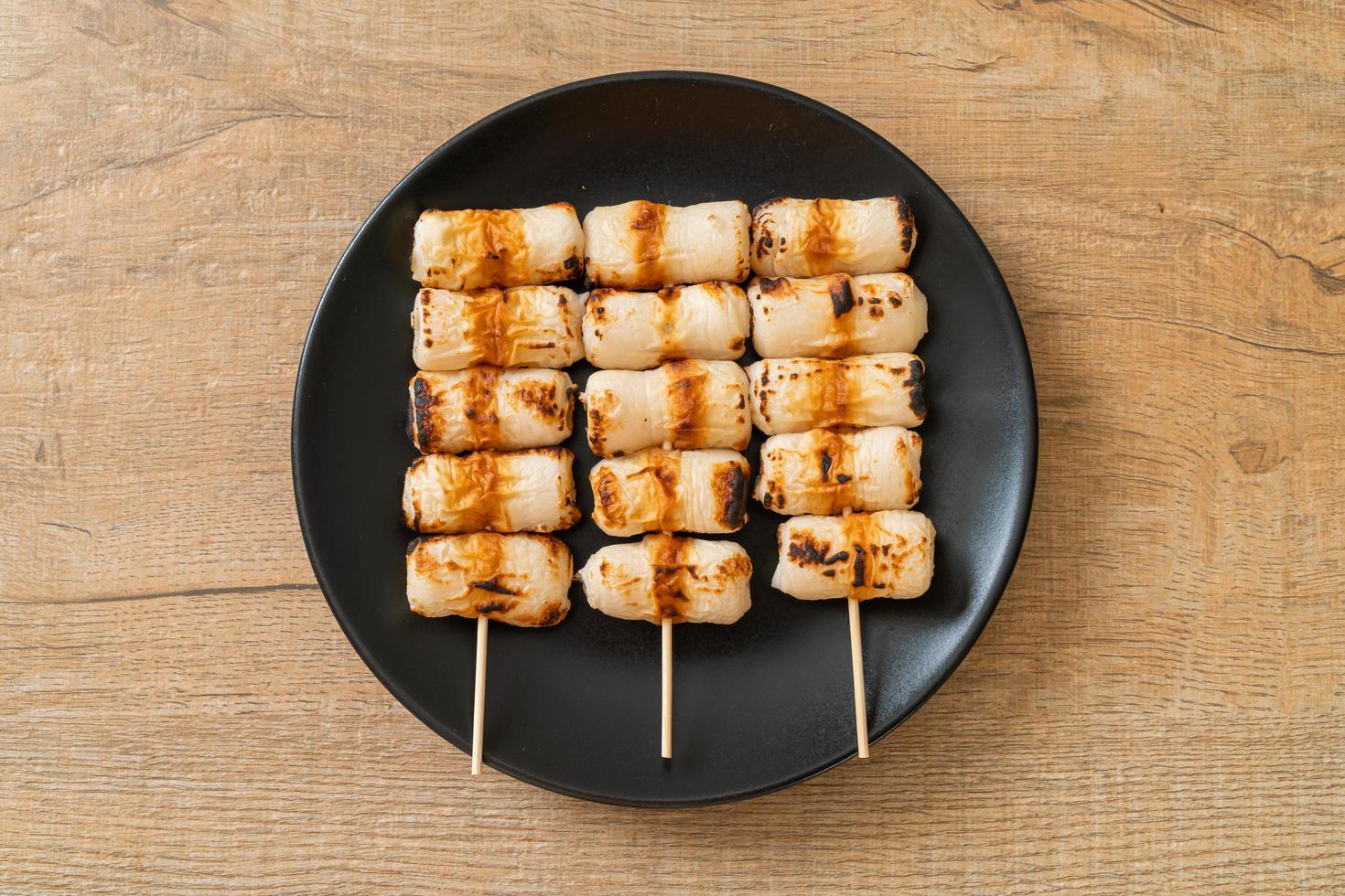 Pastel de pasta de pescado en forma de tubo a la parrilla o pincho de calamar en un plato foto