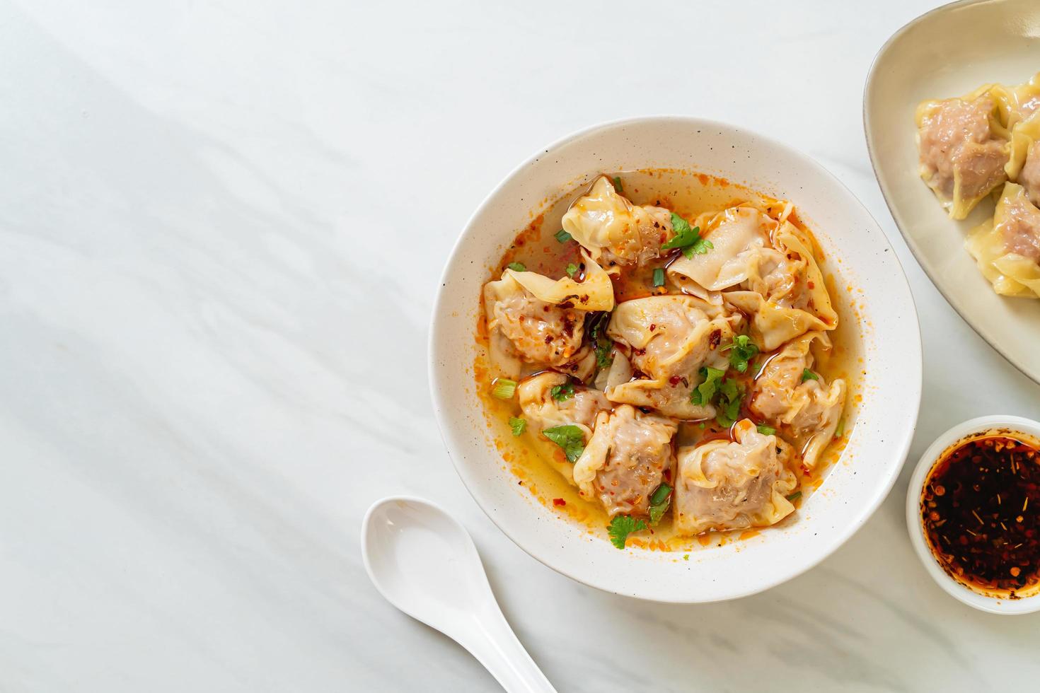 Pork wonton soup or pork dumplings soup with roasted chili - Asian food style photo