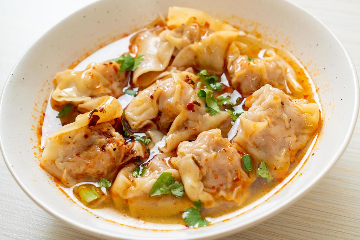 Pork wonton soup or pork dumplings soup with roasted chili - Asian food style photo