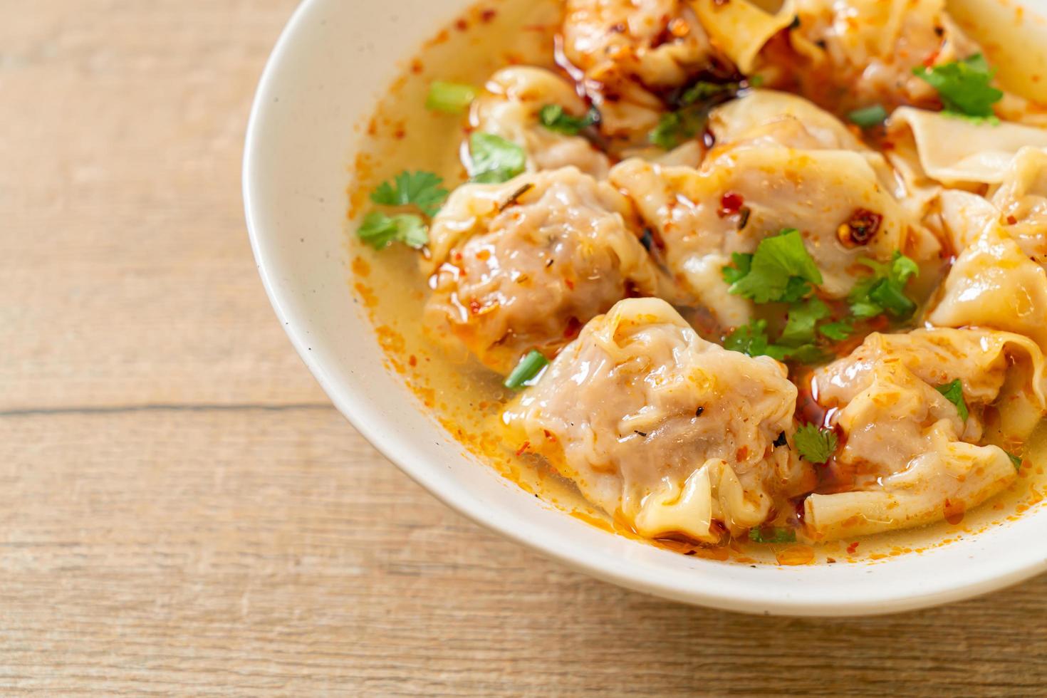 Pork wonton soup or pork dumplings soup with roasted chili - Asian food style photo