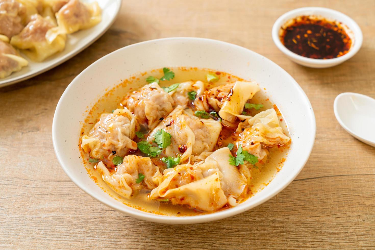 Pork wonton soup or pork dumplings soup with roasted chili - Asian food style photo