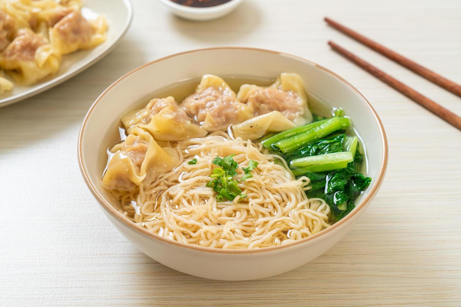 Egg noodles with pork wonton soup or pork dumplings soup and vegetable - Asian food style photo