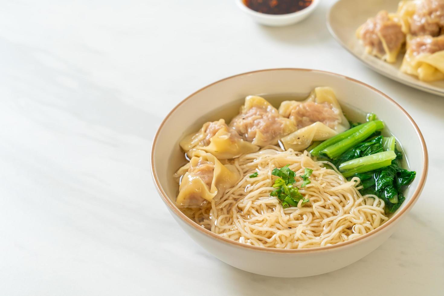 Fideos de huevo con sopa de wonton de cerdo o sopa de albóndigas de cerdo y verduras - estilo de comida asiática foto