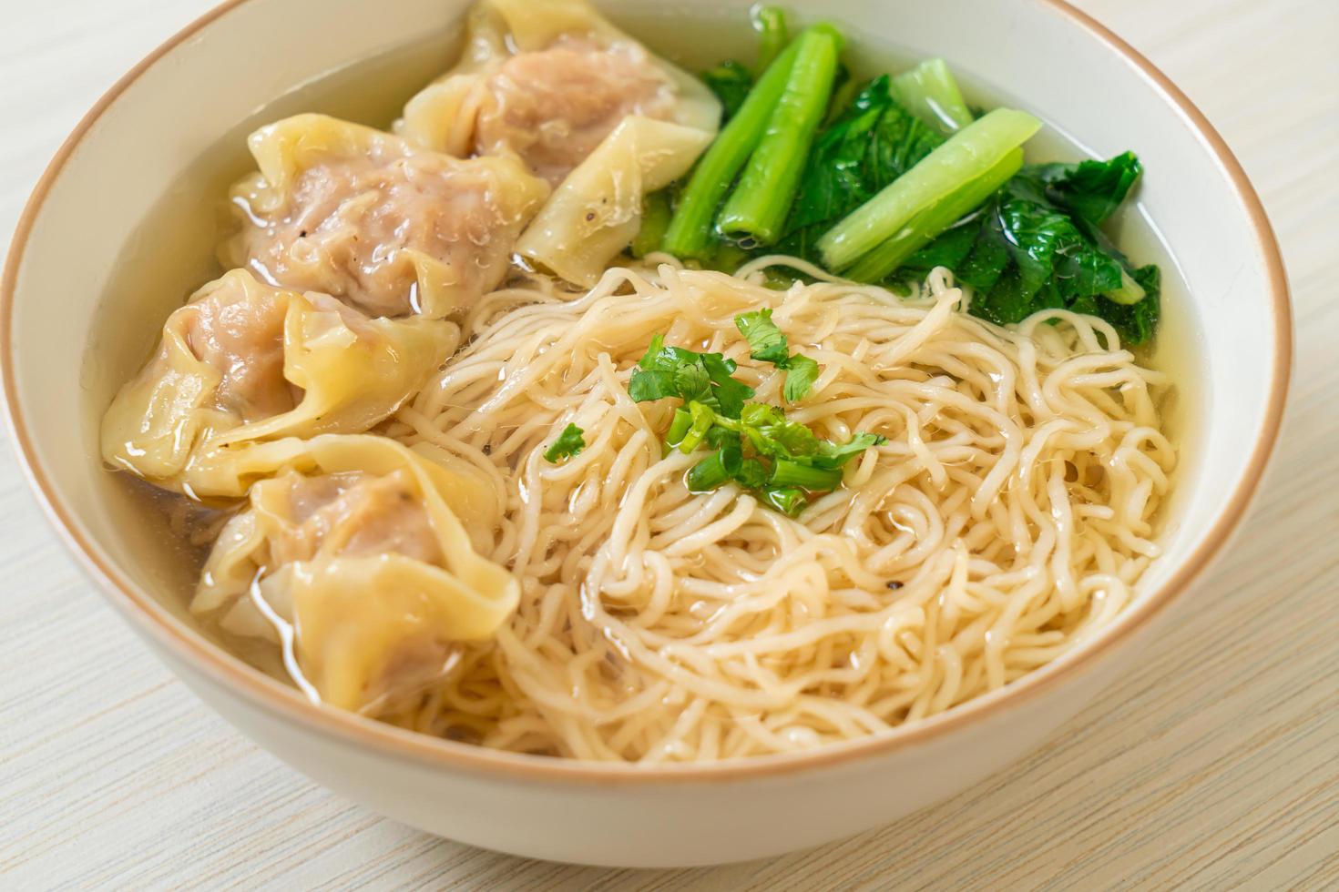 Egg noodles with pork wonton soup or pork dumplings soup and vegetable - Asian food style photo