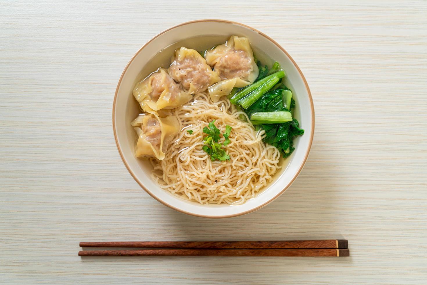 Egg noodles with pork wonton soup or pork dumplings soup and vegetable - Asian food style photo