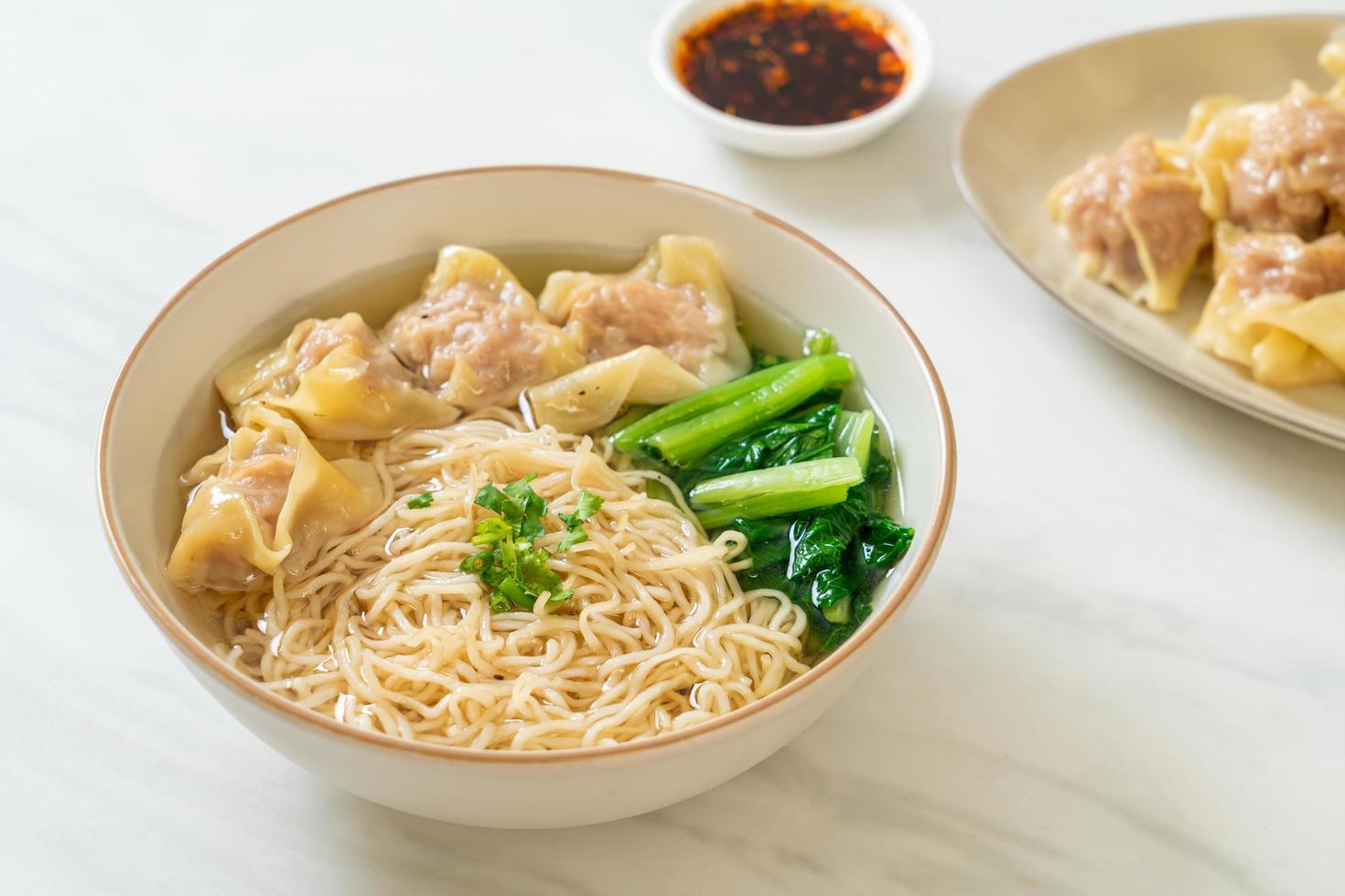 Fideos de huevo con sopa de wonton de cerdo o sopa de albóndigas de cerdo y verduras - estilo de comida asiática foto