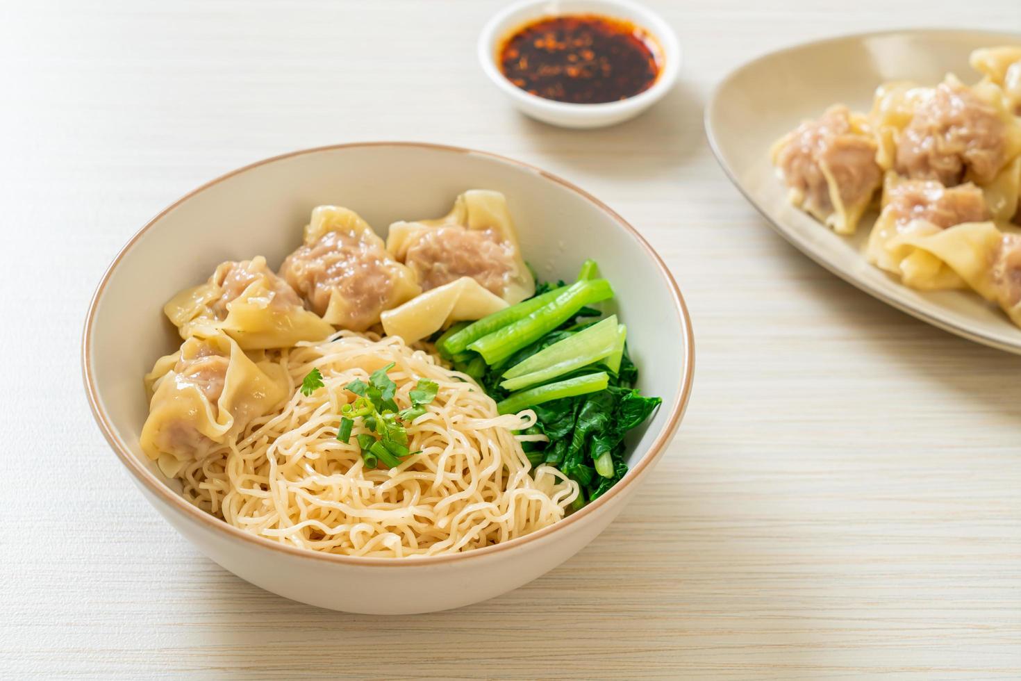 Dried egg noodles with pork wonton or pork dumplings without soup - Asian food style photo