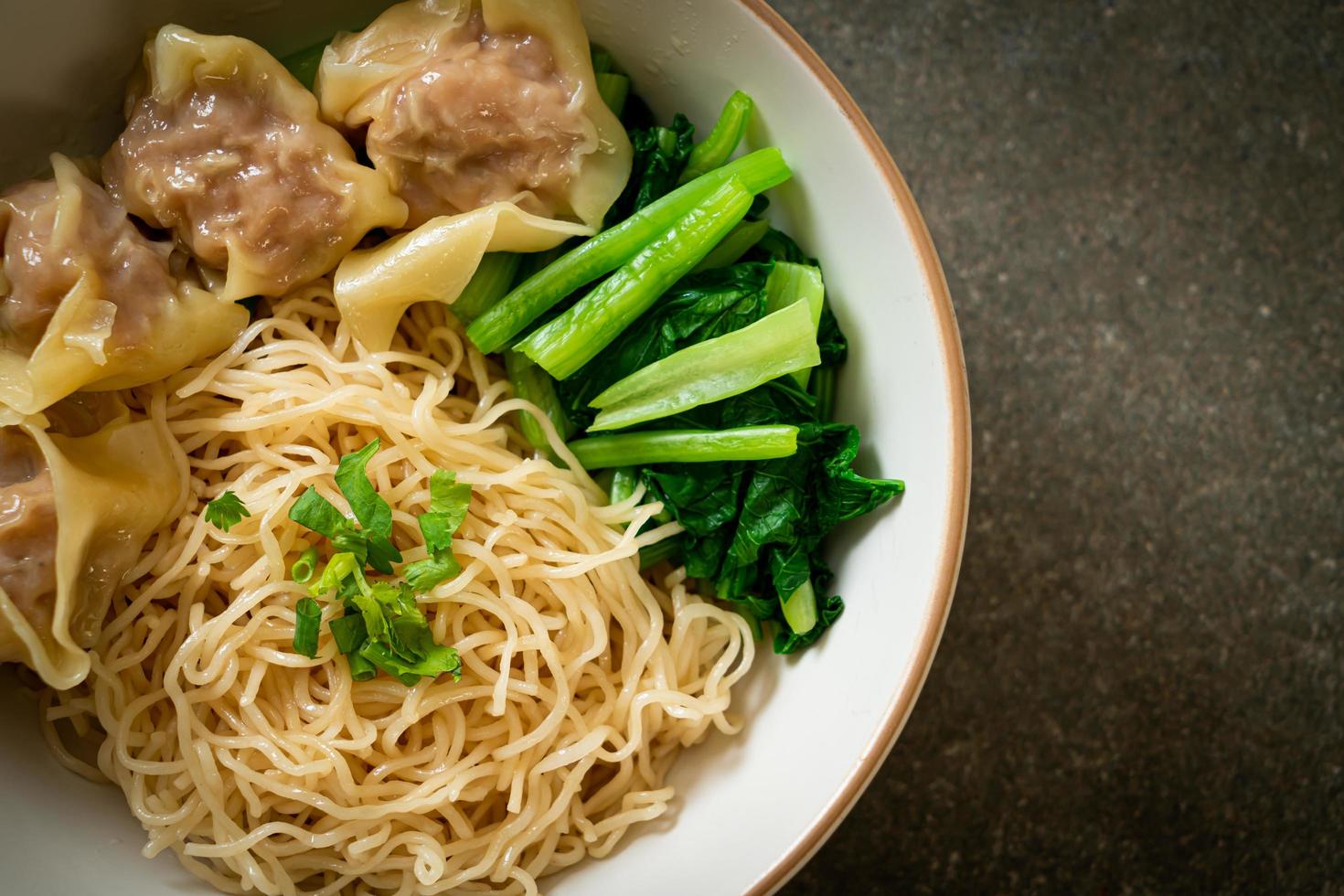 Dried egg noodles with pork wonton or pork dumplings without soup - Asian food style photo