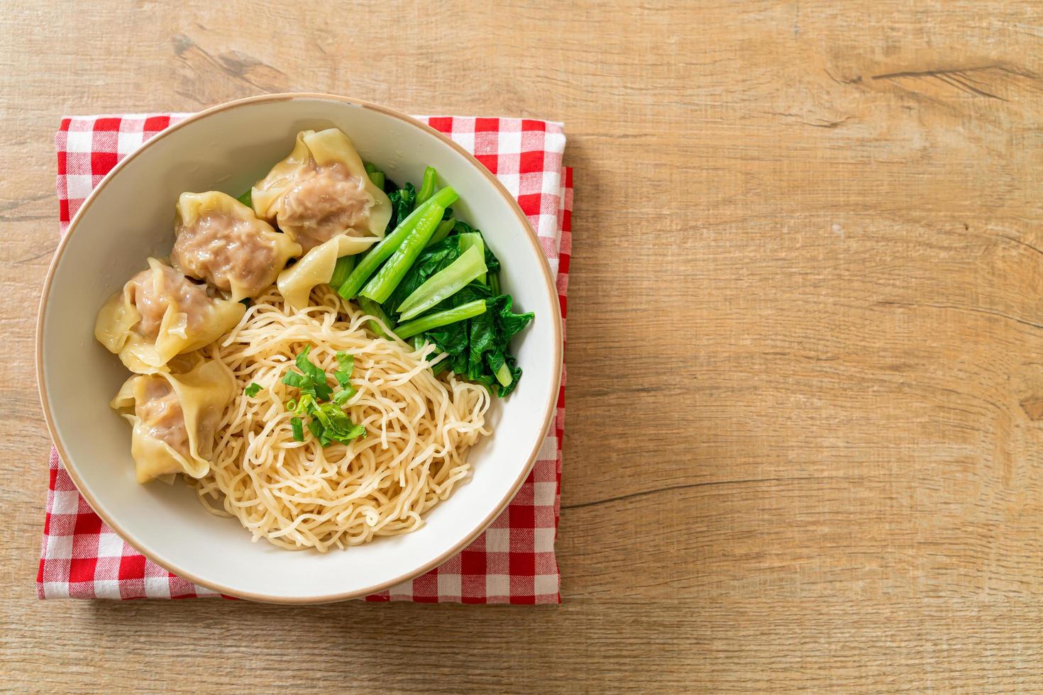 Dried egg noodles with pork wonton or pork dumplings without soup - Asian food style photo