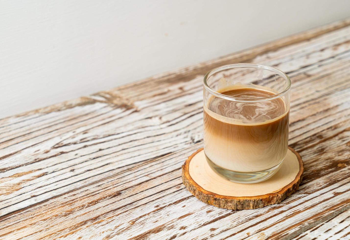 Glass of latte coffee, coffee with milk on wood background photo