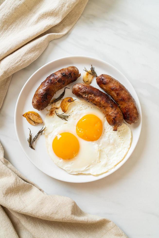 Doble huevo frito casero con salchicha de cerdo frita para desayunar foto