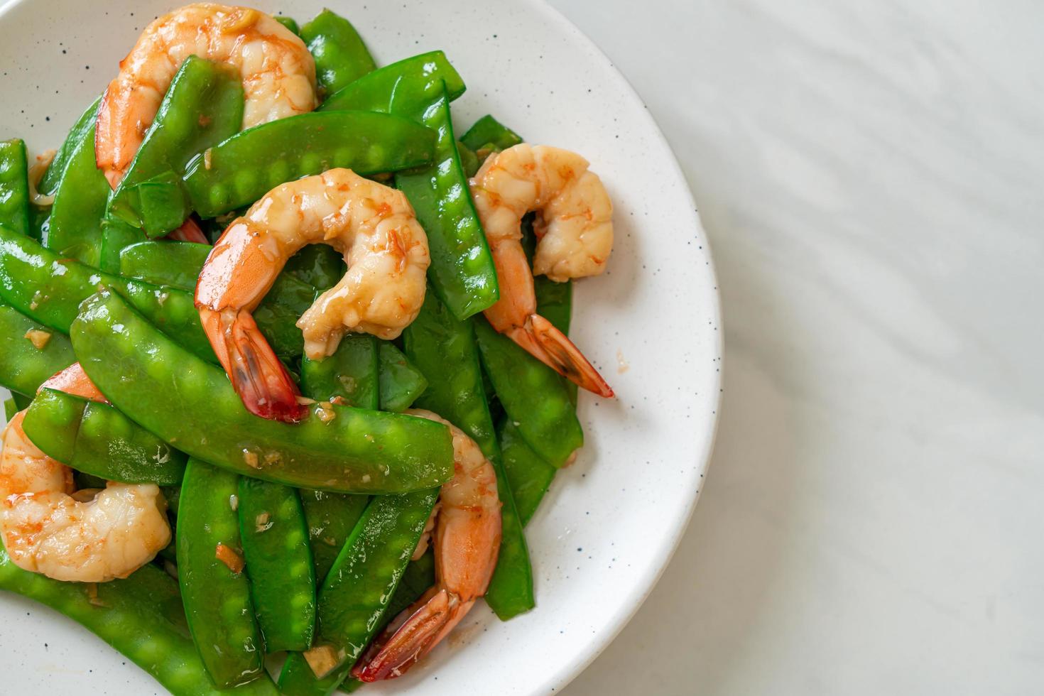 guisantes salteados con camarones - estilo de comida casera foto