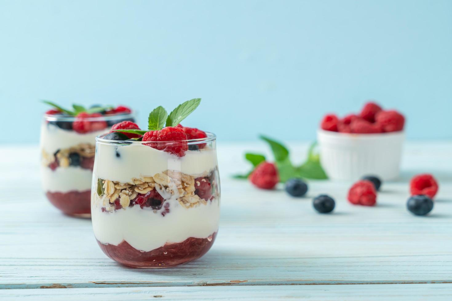 frambuesa y arándano casero con yogur y granola - estilo de comida saludable foto