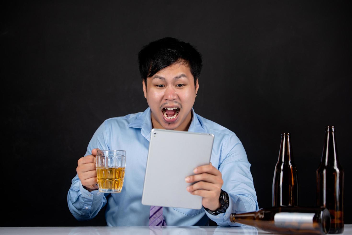 Business man holding laptop with beer photo
