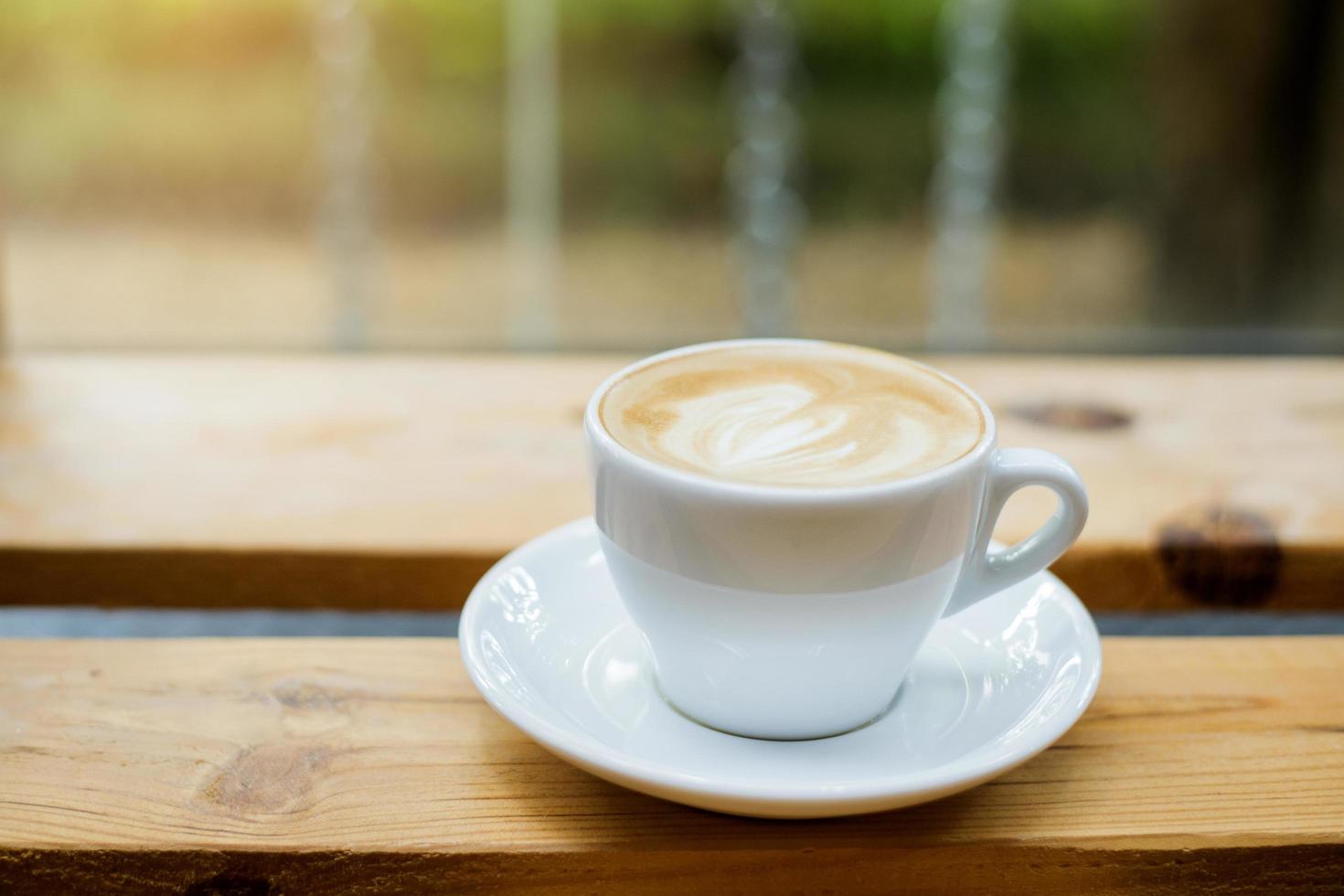 Arte latte caliente sobre fondo de mesa de madera foto