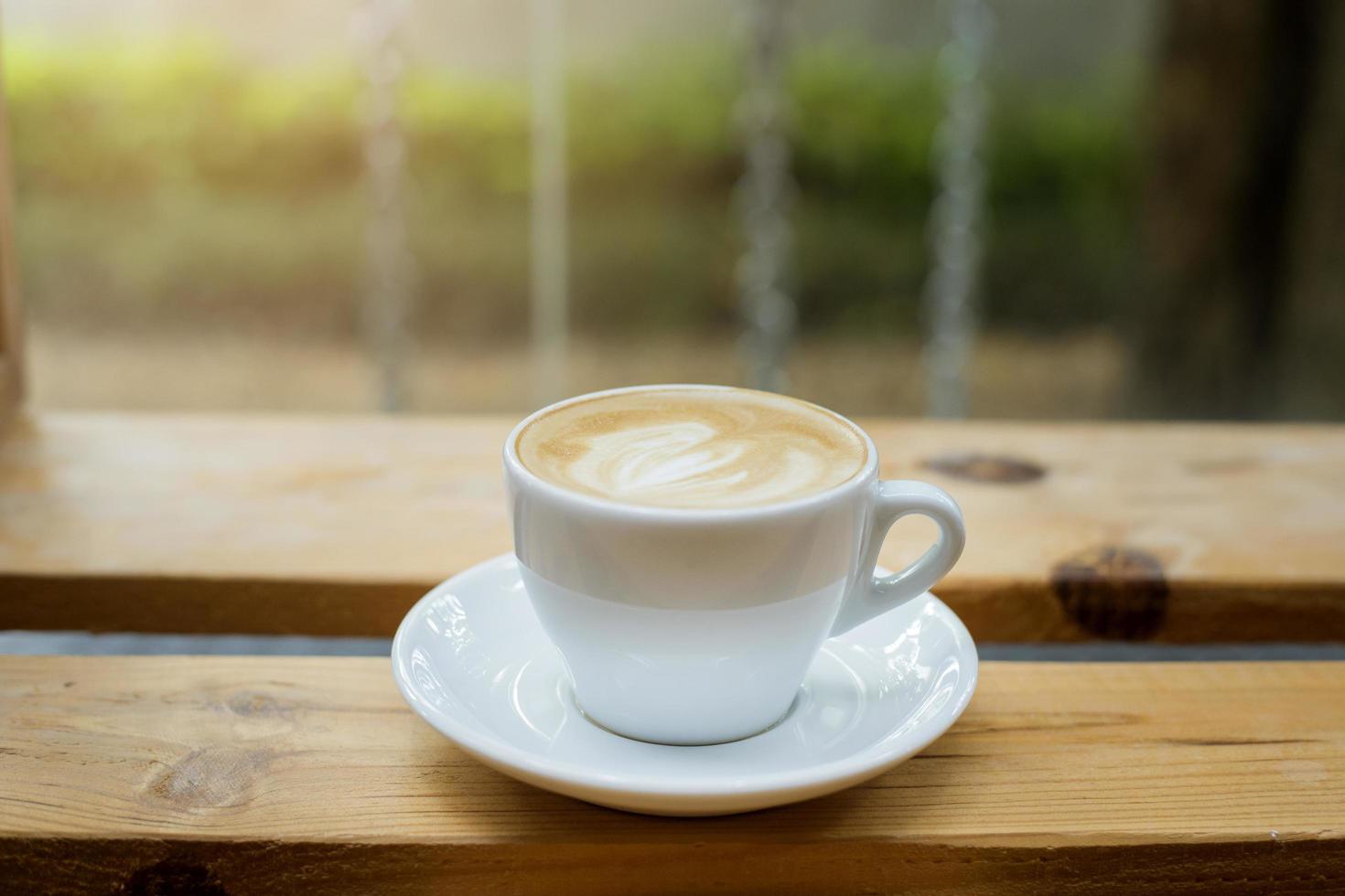 Hot latte art on wood table background photo