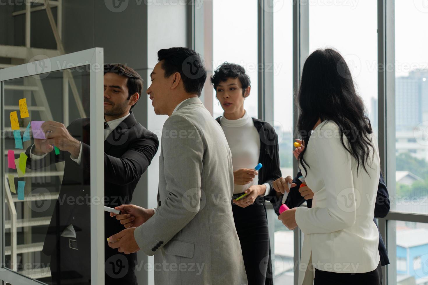 Multiethnic business team including caucasian and asian people working together in office photo