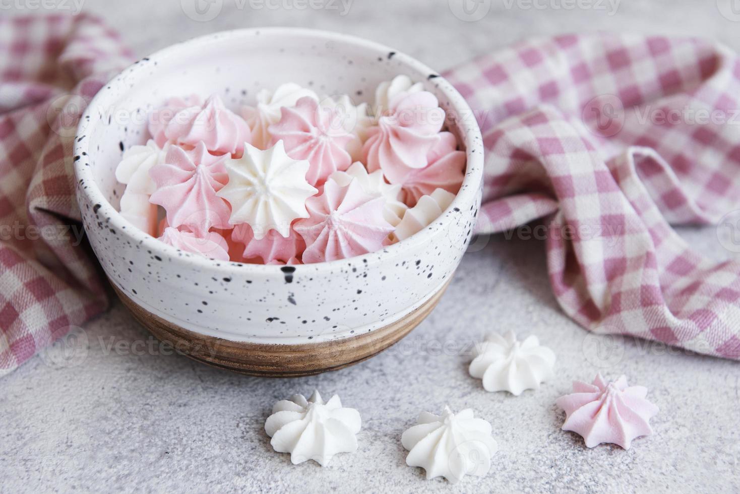 pequeños merengues blancos y rosas en el cuenco de cerámica foto