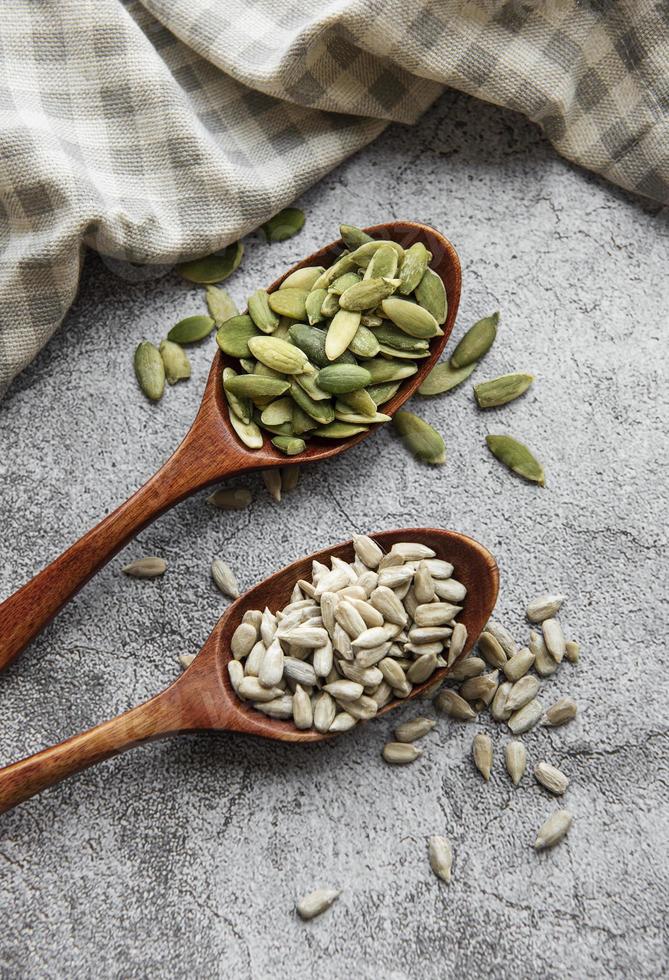 Wooden spoons with sunflower seeds and pumpkin seeds photo