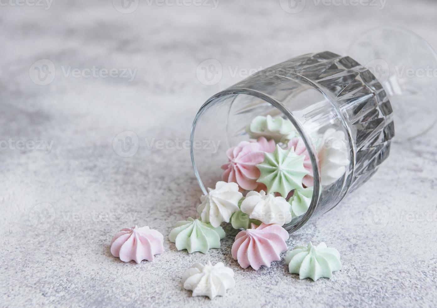 pequeños merengues blancos, rosas y verdes en el vaso foto