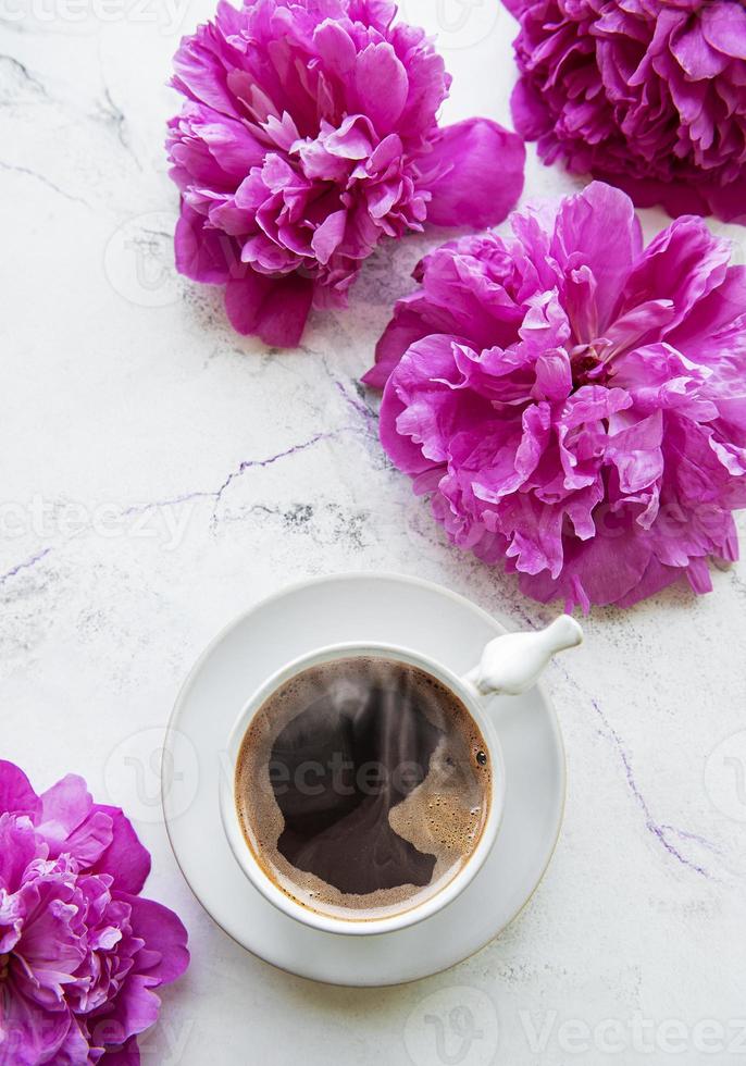 flores de peonía rosa y taza de café foto