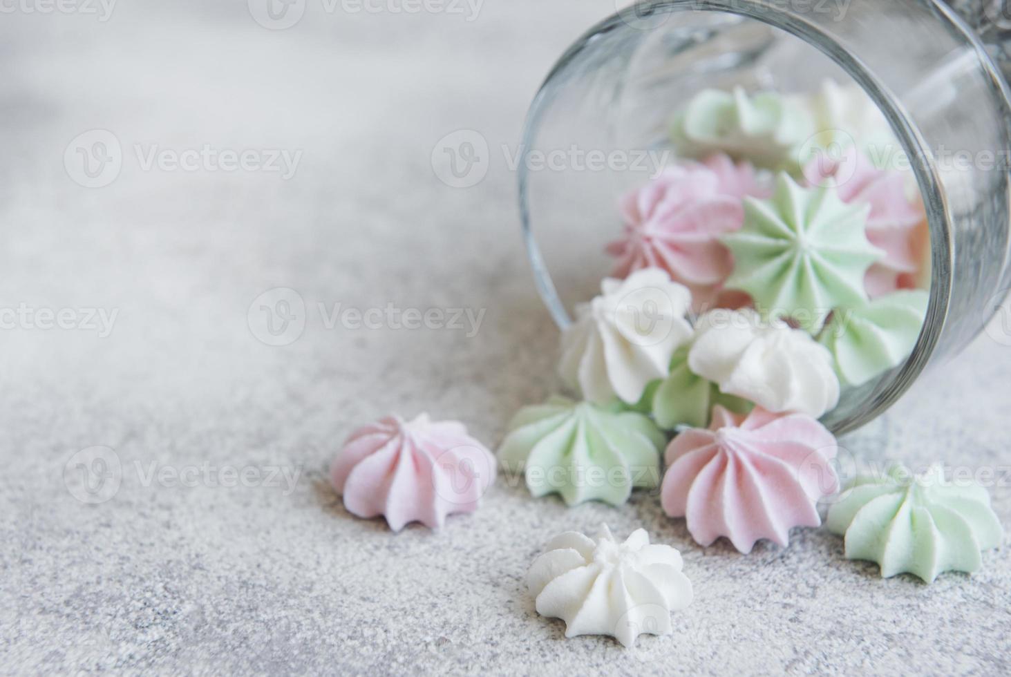 pequeños merengues blancos, rosas y verdes en el vaso foto