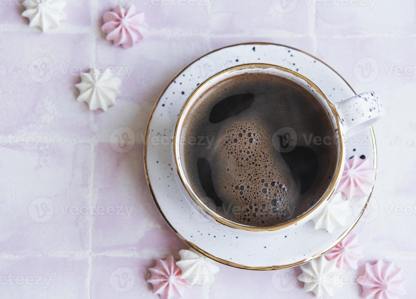 taza con café y pequeños merengues foto