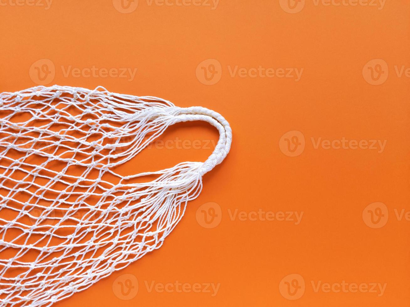 White string cotton eco bag on orange background Simple flat lay with copy space Ecology zero waste concept Stock photography photo