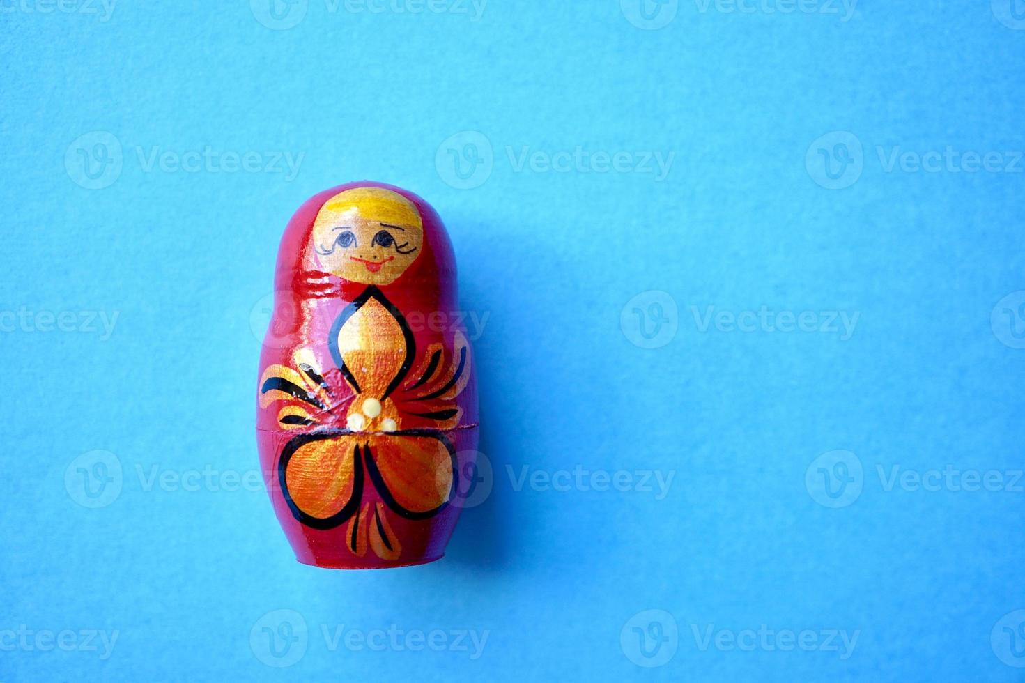 Muñeca matrioshka roja sobre fondo azul. foto