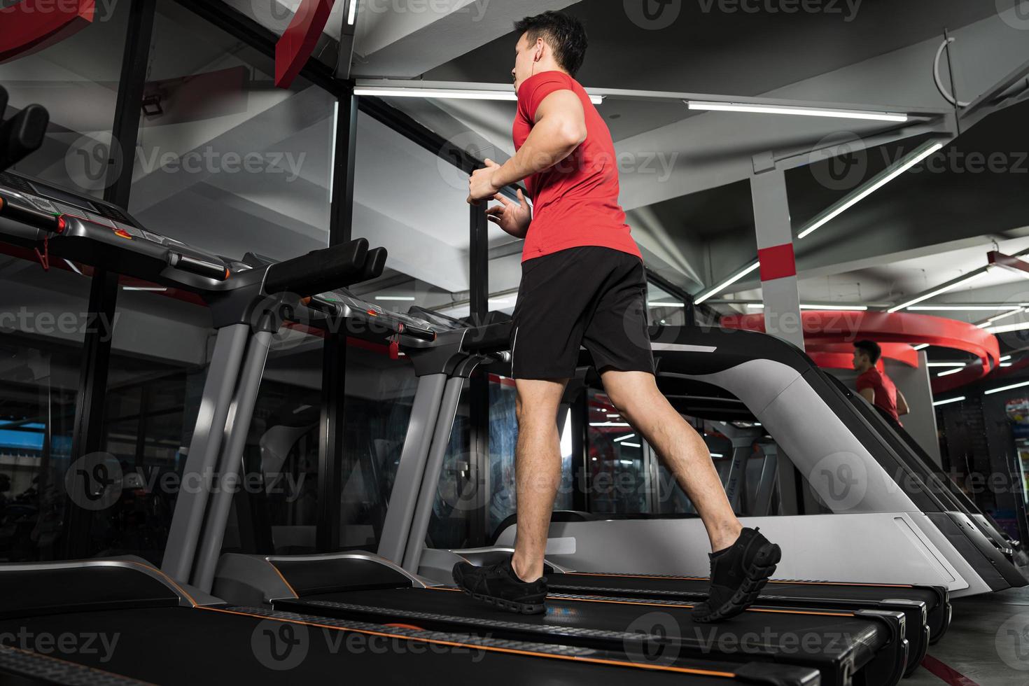 Athletic young man running in gym  Sport fitness training photo