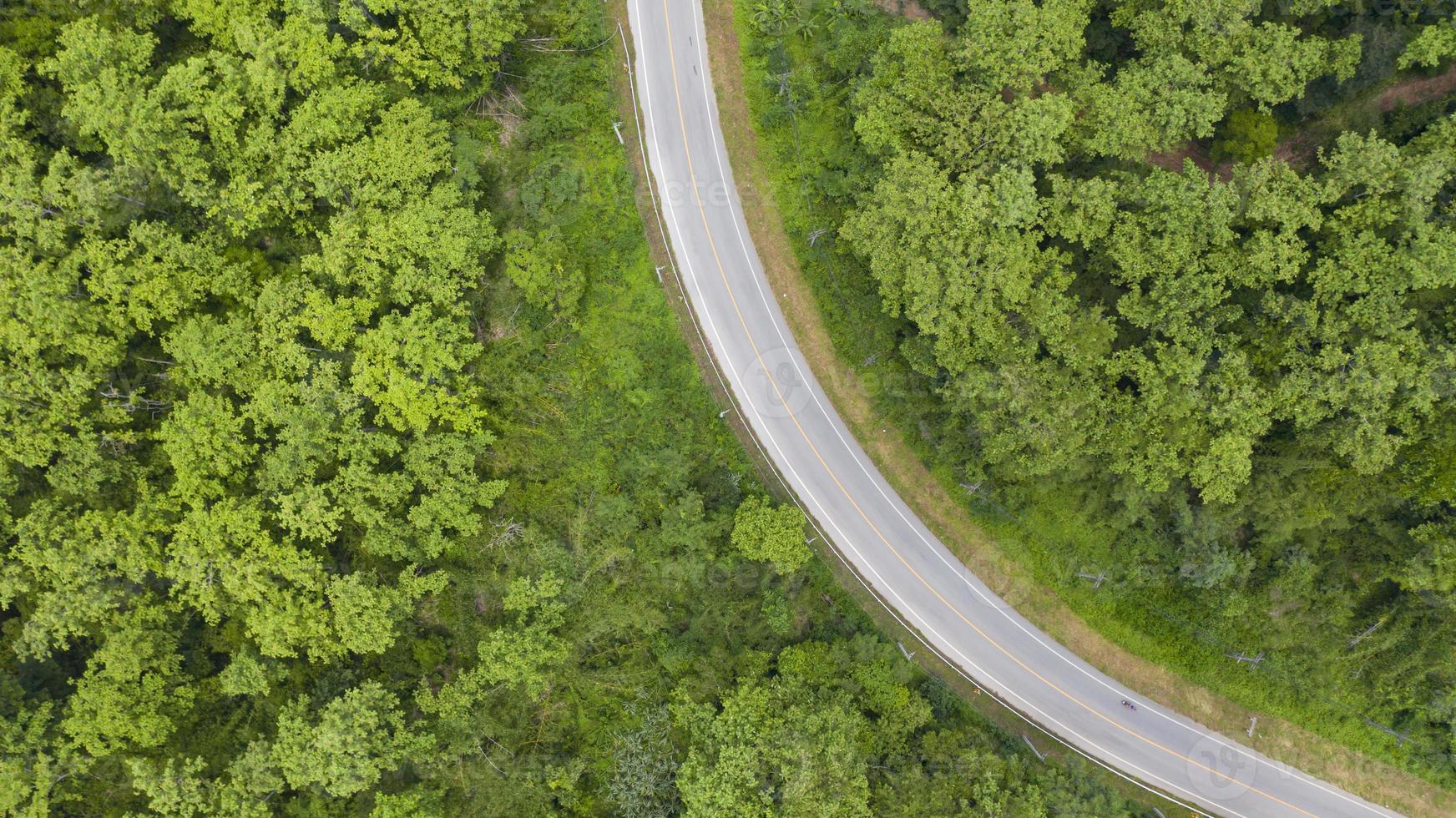 Aerial top view of a provincial road passing through a forest background photo