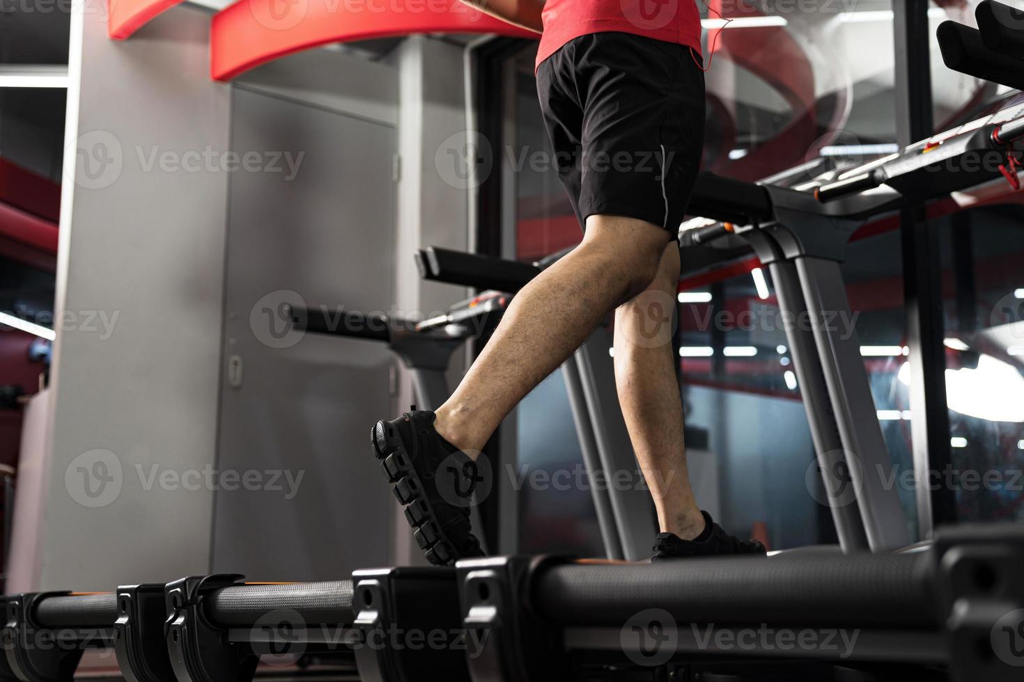 Close up of male legs running on treadmill in gym Sport fitness training  Lifestyle people concept photo