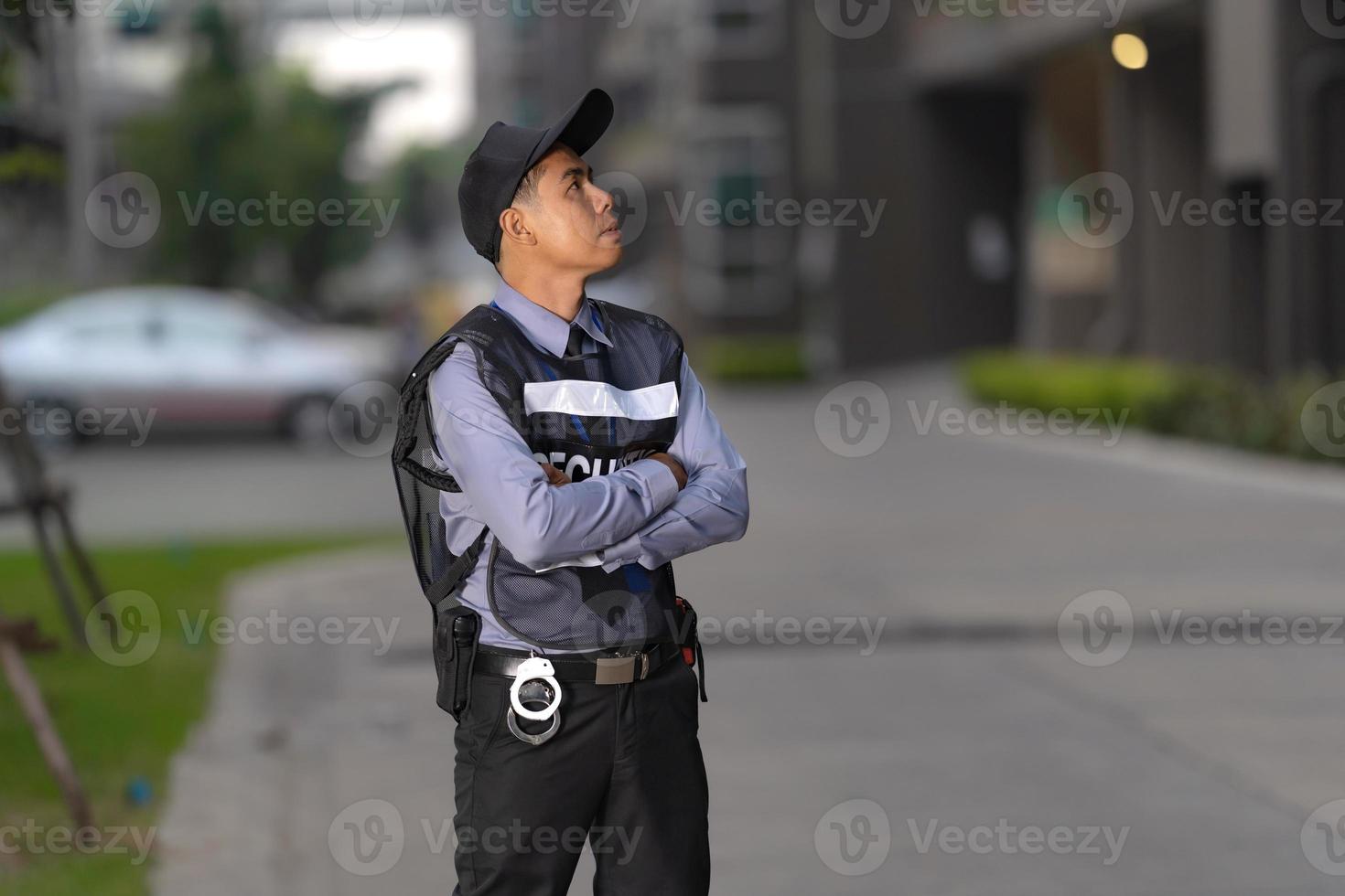 hombre de seguridad de pie al aire libre cerca del gran edificio foto