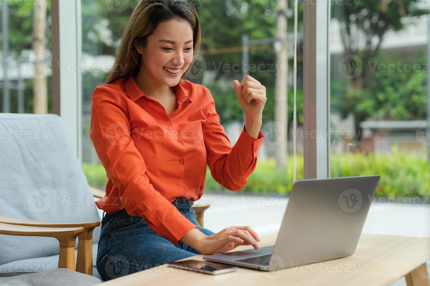 Hermosa joven con laptop sentada en una cafetería. foto