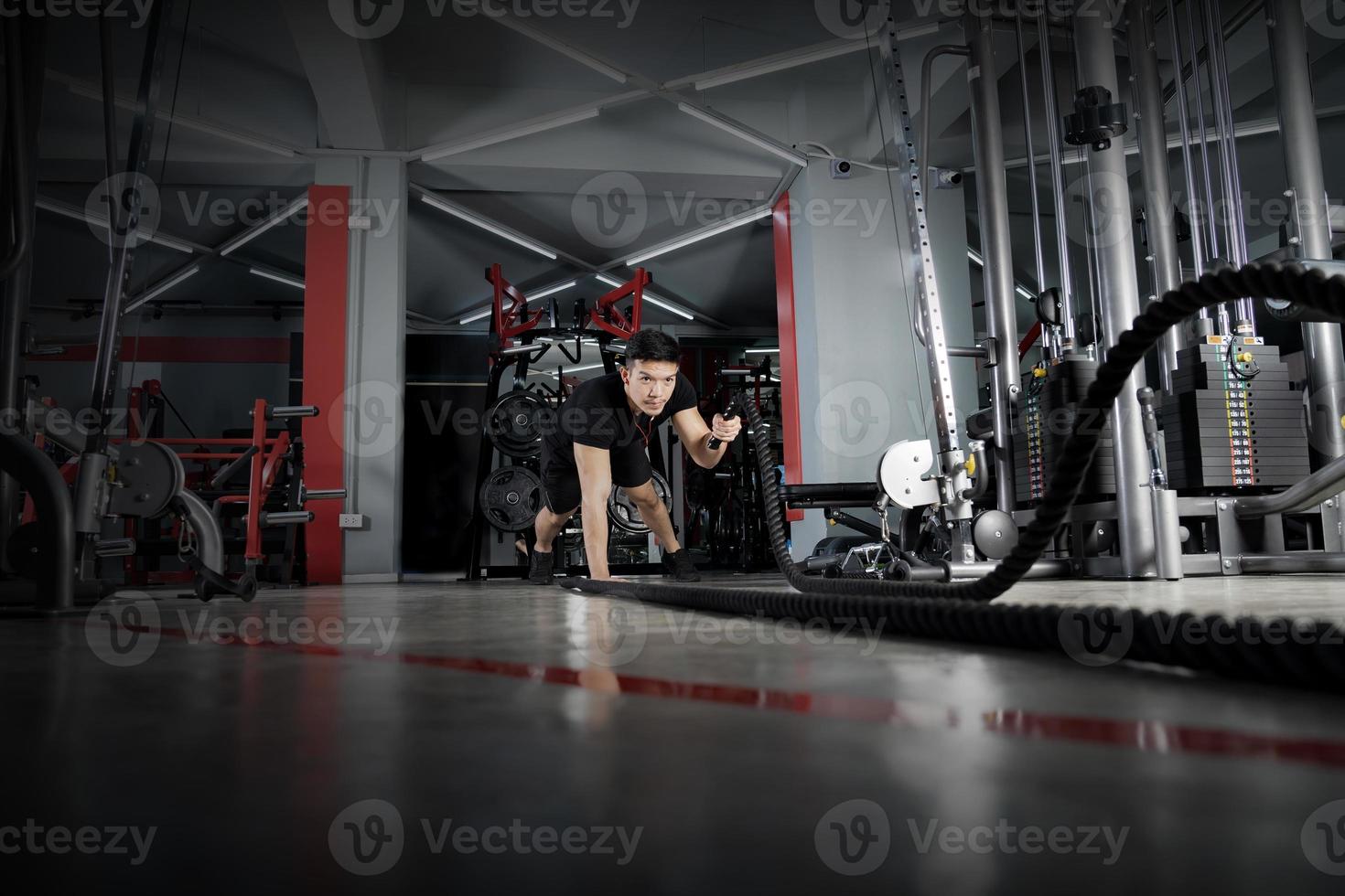 Man working out with battle ropes at gym photo