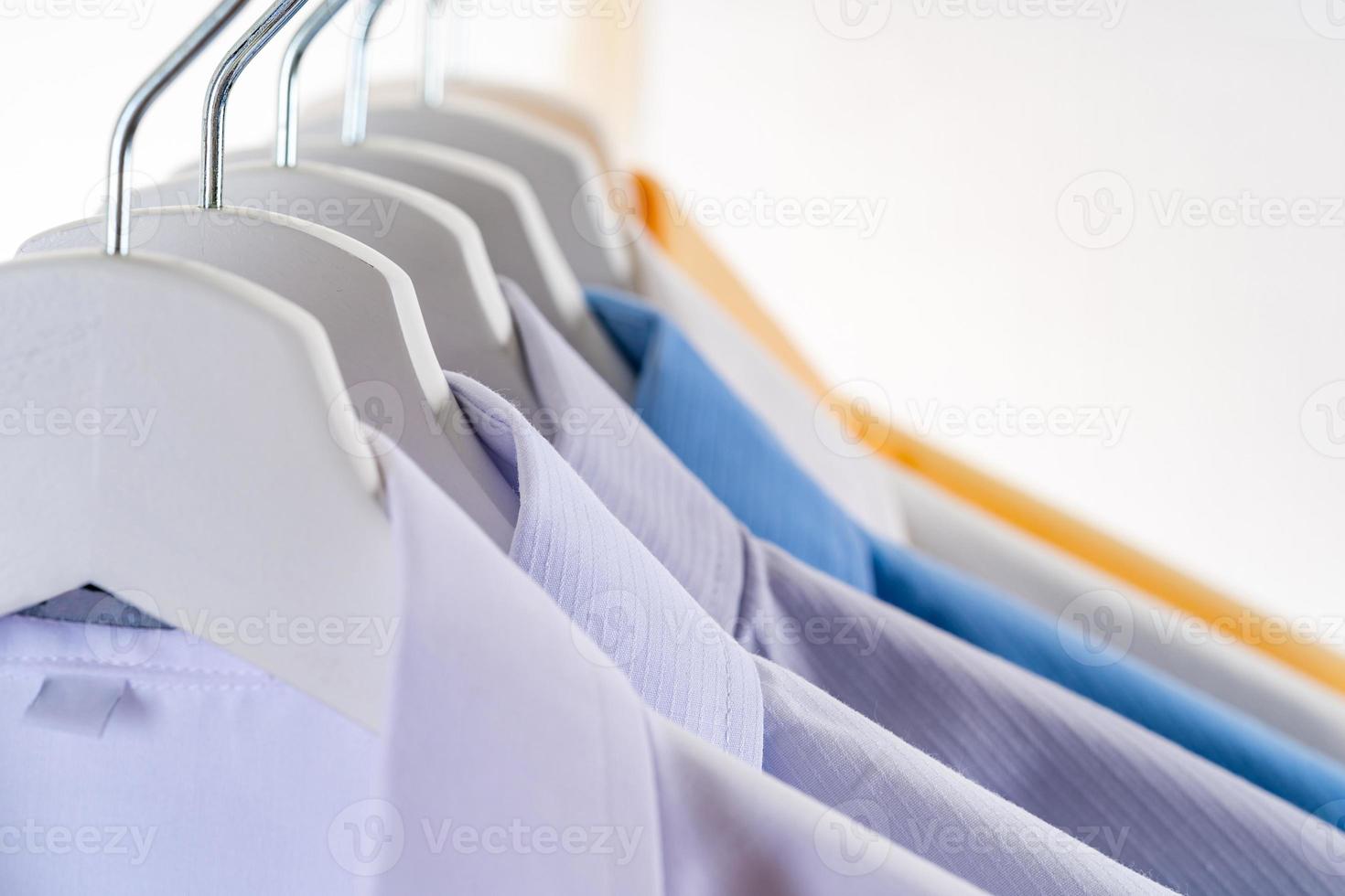 Men dress shirts Clothes on hangers on white background photo