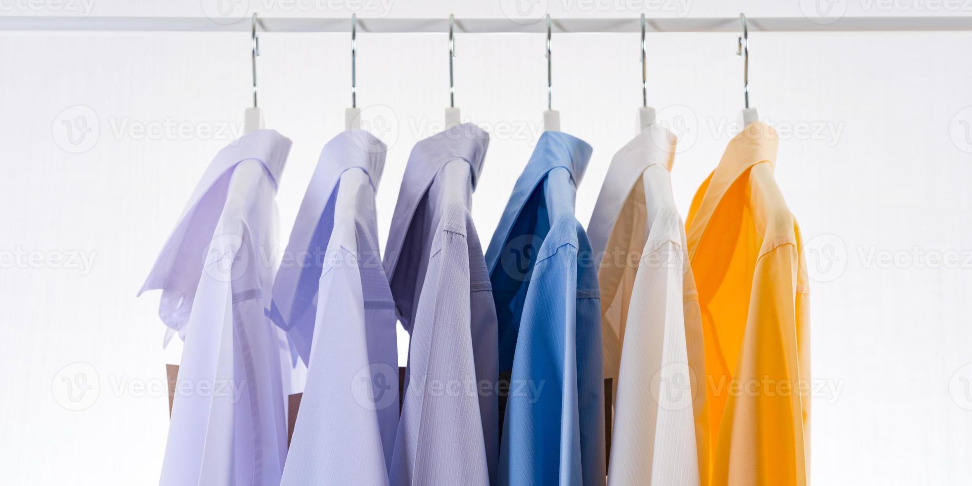 Men dress shirts Clothes on hangers on white background photo