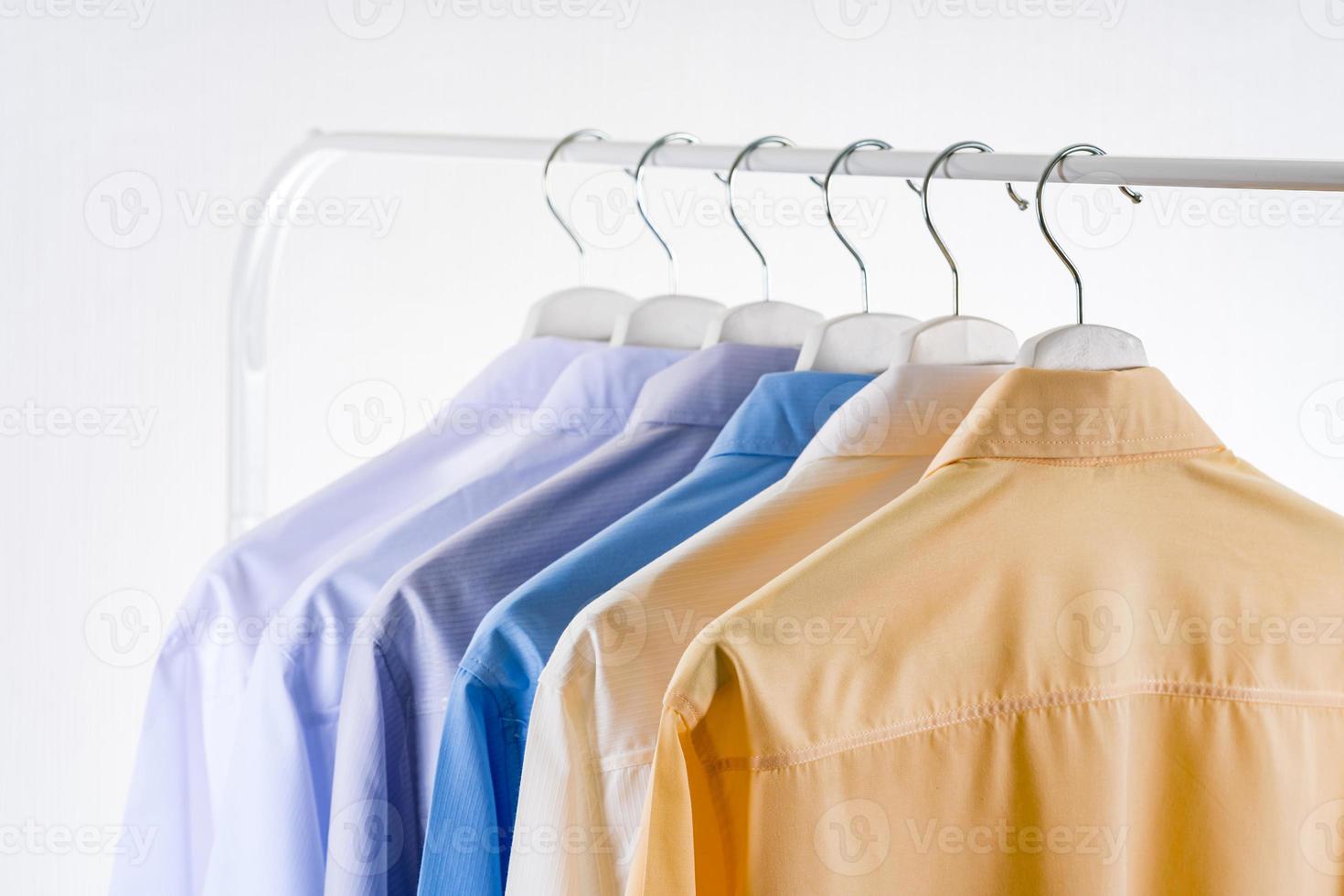 Men dress shirts Clothes on hangers on white background photo