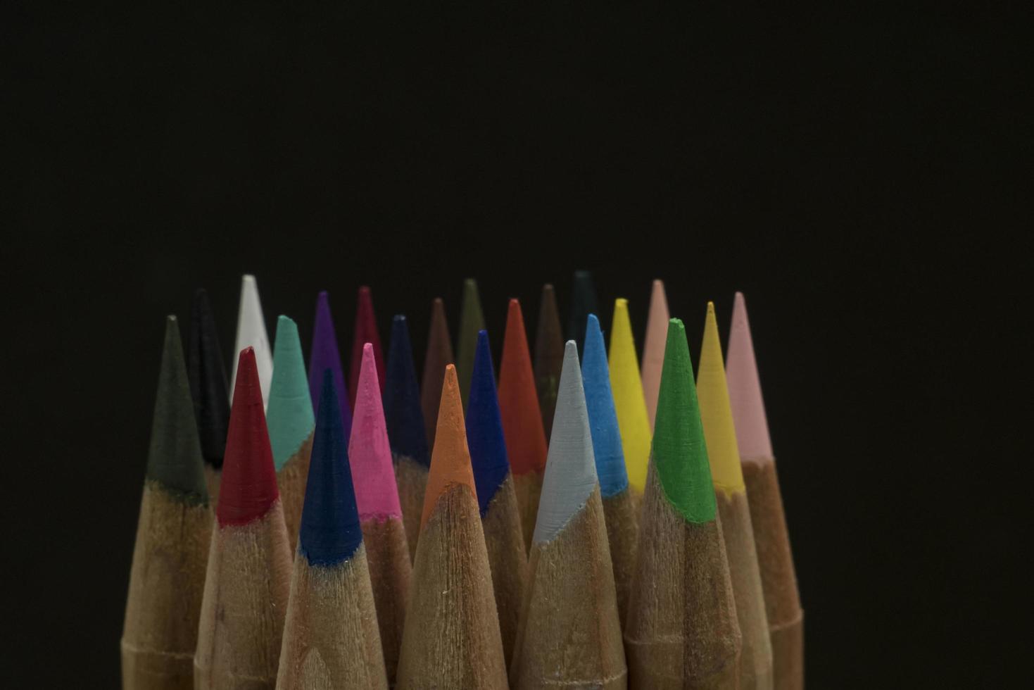 Lápices de colores afilados en un espacio de copia de fondo negro foto